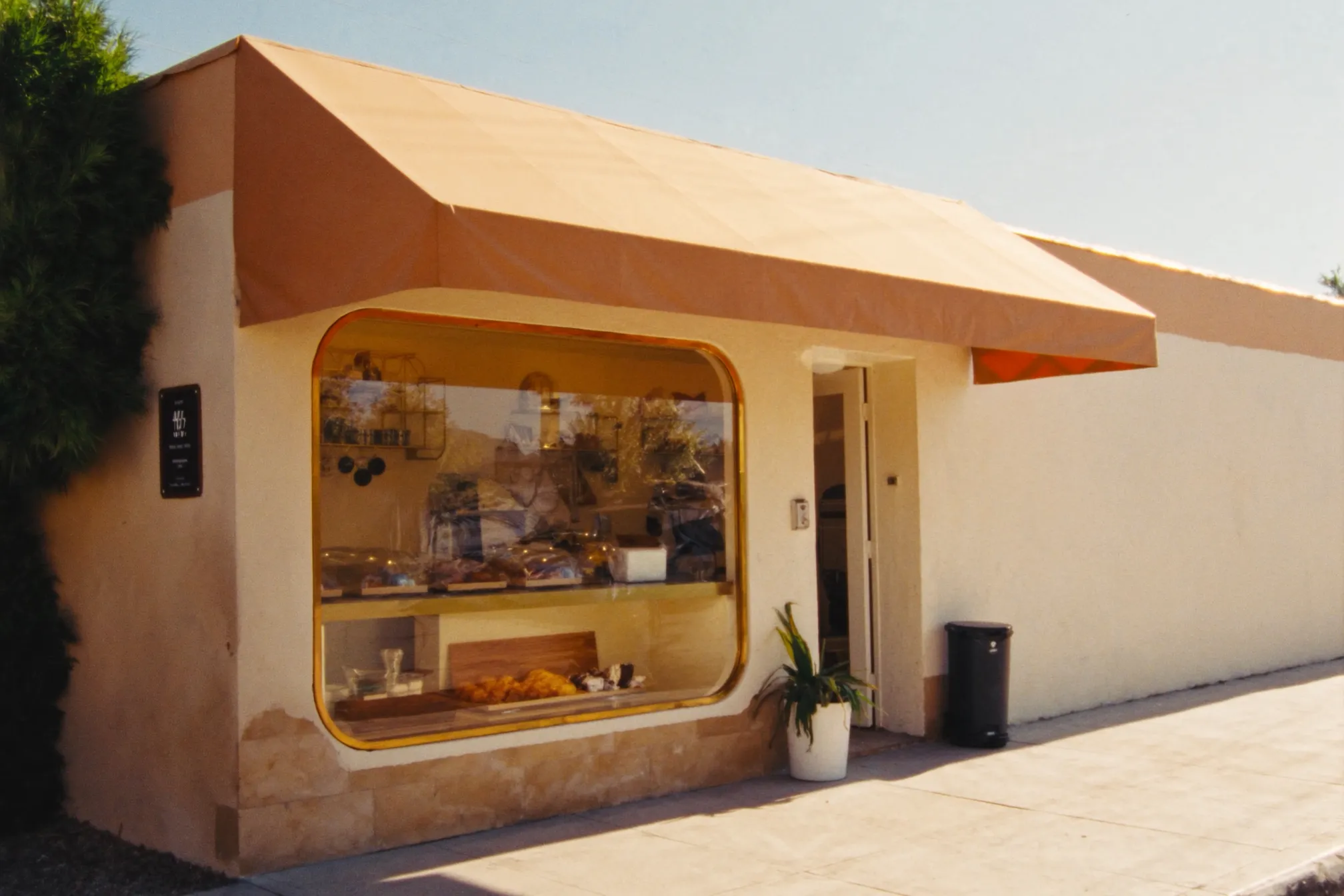 Fachada luminosa de un negocio local con toldo ámbar